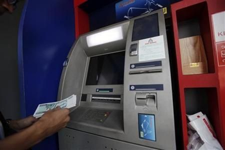 A man uses an ATM machine at KBZ bank's head office in Yangon March 14, 2012 Reuters pic