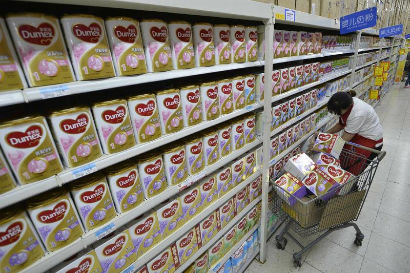 A sales assistant takes down Dumex milk powder products from shelves, which were included in a recall by Fonterra, at a supermarket in Taiyuan, Shanxi province, August 5, 2013