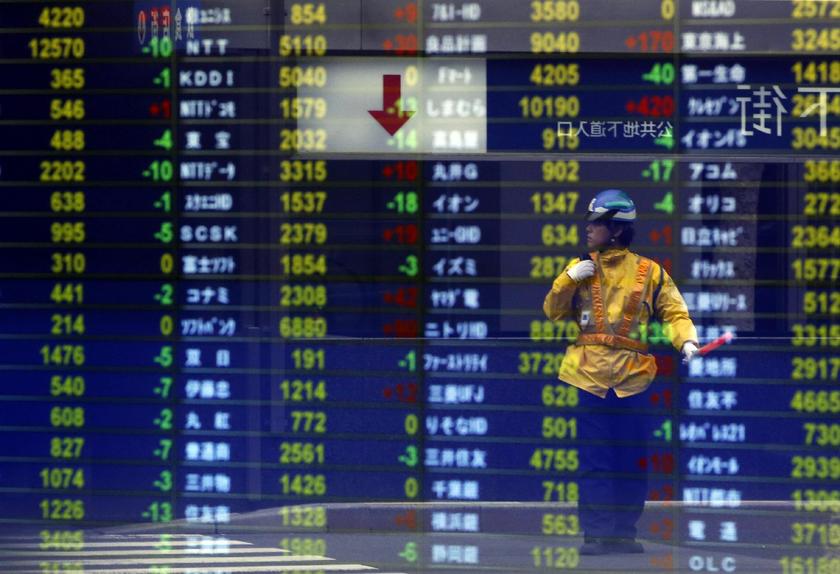 A traffic controller at a constructing site is reflected on a stock quotation board at a brokerage in Tokyo October 1, 2013 Reuters pic