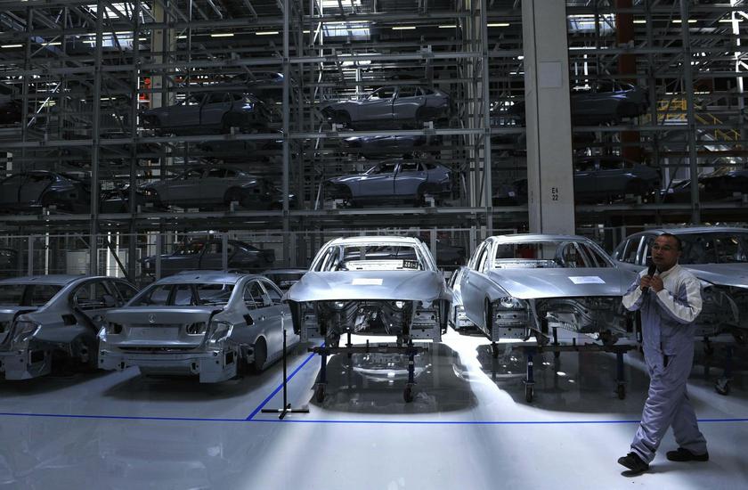 An employee guides visitors inside a BMW factory in Shenyang, Liaoning province, July 6, 2013