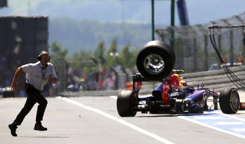 An unidentified FIA official runs over to the pits as a lost rear tyre of Red Bull Formula One driver Mark Webber of Australia bounces through the pit lane during the German F1 Grand Prix at the Nuerburgring circuit on July 7, 2013. u00e2u20acu201d Reuters pic