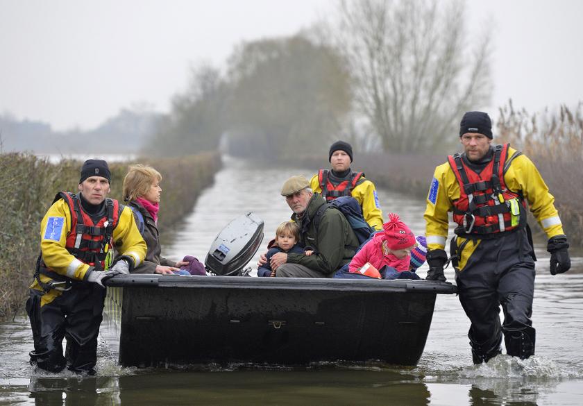 A boat operated by emergency services personnel carries local residents along a flooded road from the village of Muchelney on the Somerset Levels, near Langport in south west England January 30, 2014.