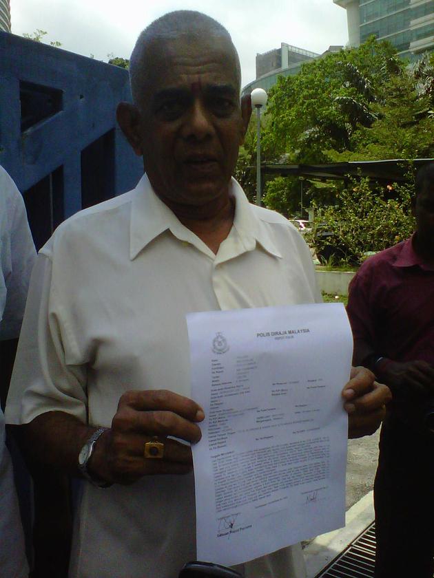 Ramakrishnan holds a copy of the police report he made, outside the Jalan Travers police station in Kuala Lumpur today. — Picture by Liyana Shazreen