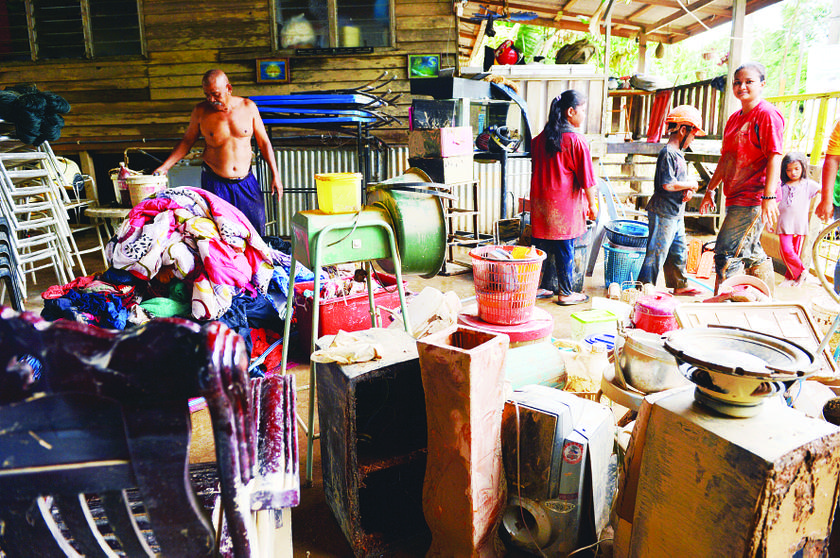 Zulhisham Mohd and his family search for whatever is left of their home after it collapsed in the flood in Kemaman, December 11, 2013..  u00e2u20acu201d Picture by Hadzme Mohd Jaafar