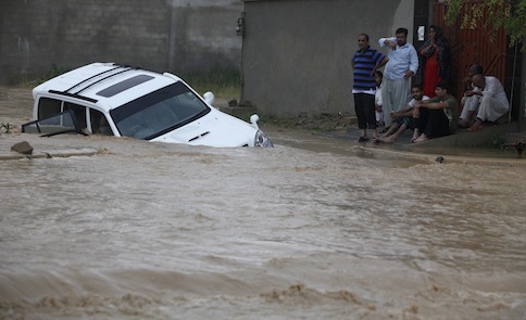 Family members wait for rescue workers after their vehicle was submerged in flood waters on the outskirts of Karachi August 4, 2013. u00e2u20acu201d Reuters pic