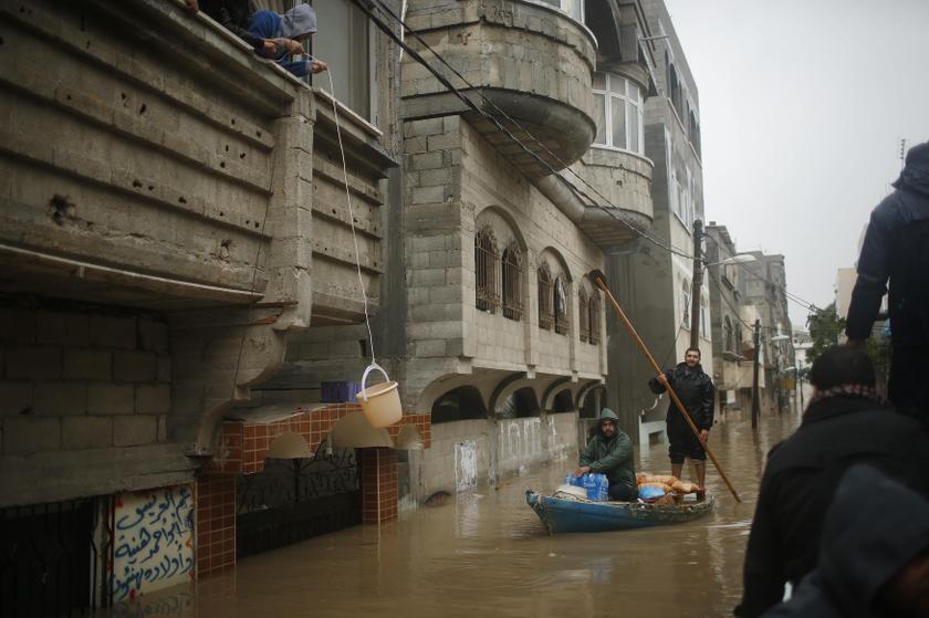 Palestinian policemen loyal to the Hamas operate a boat carrying bread, to be passed to people whose houses were flooded with rainwater on a stormy day, in the northern Gaza Strip December 14, 2013. u00e2u20acu201d Reuters pic
