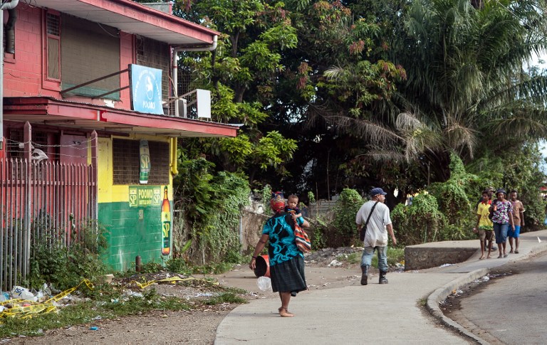 Local residents walk in front a bakery where four Asian expatriates were murdered, in Port Moresby on June 26, 2013. u00e2u20acu201c AFP pic