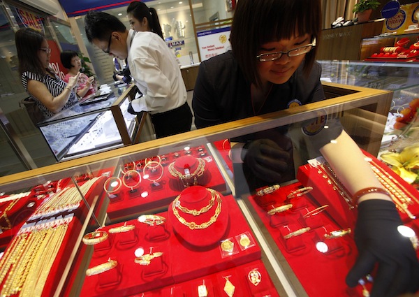 An employee arranges gold jewellery as customers shop at a MoneyMax pawnshop outlet in Singapore August 23, 2013. — Reuters pic