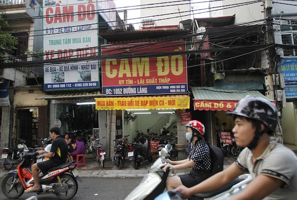 People ride motorcycles past pawnshops in Hanoi September 9, 2013. — Reuters pic
