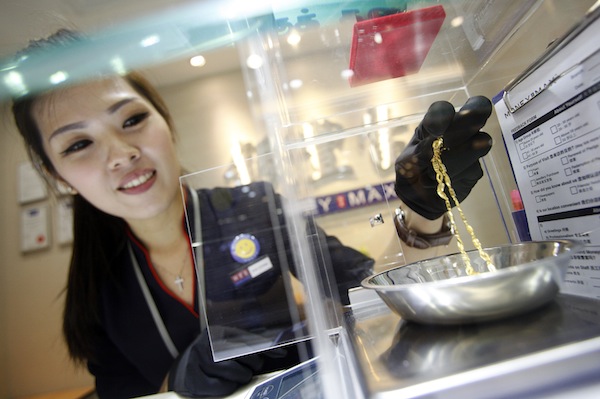 Valuer Eve Chong, demonstrates the valuation process for jewellery at a MoneyMax pawnshop outlet in Singapore August 23, 2013. u00e2u20acu201d Reuters pic
