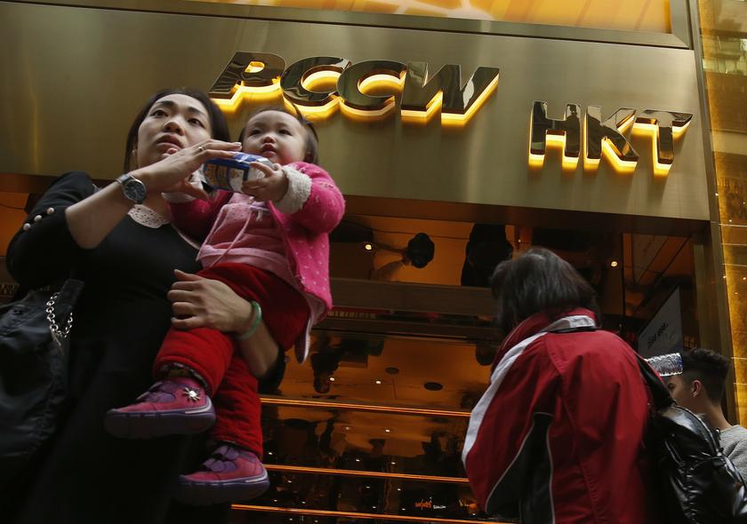 People walk past company logos of PCCW and Hong Kong Telecom (HKT) outside one of its shops in Hong Kong December 20, 2013. u00e2u20acu201d Reuters pic