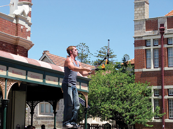 Fire-thrower performing outside Fremantle Markets on a sunny weekend
