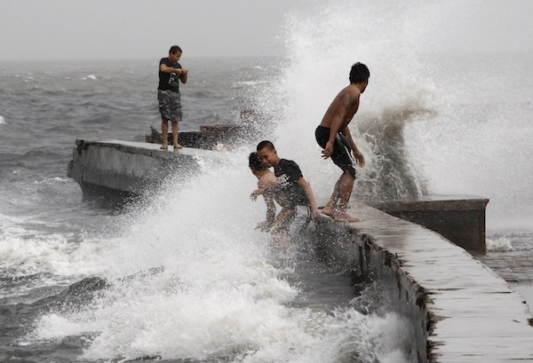 Teenagers play in the crashing waves of Manila bay at a flooded park along the coastal areas of Navotas city, metro Manila August 18, 2013. u00e2u20acu201d Reuters pic
