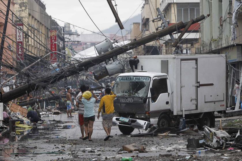 Survivors walk under a fallen electric post after super Typhoon Haiyan battered Tacloban city, central Philippines November 10, 2013. u00e2u20acu201d Reuters pic
