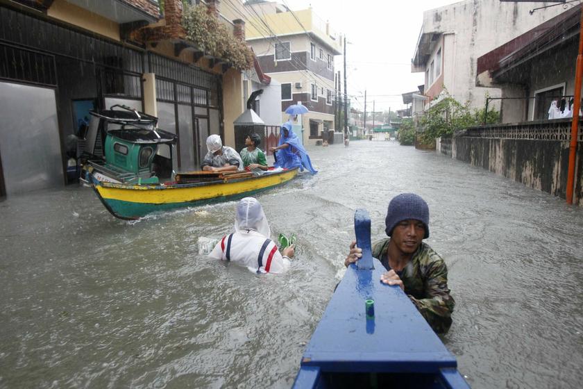 Residents wade in floodwaters brought by monsoon rain, intensified by tropical storm Trami, in Kawit town of Cavite city, south of Manila August 19, 2013