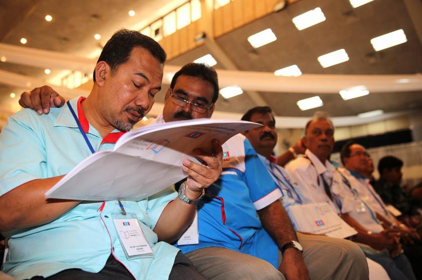 Delegates examining a draft of the proposed amendments to the PKR constitution during the PKR Special National Congress in Shah Alam November 24, 2013. u00e2u20acu201d Picture by Choo Choy May