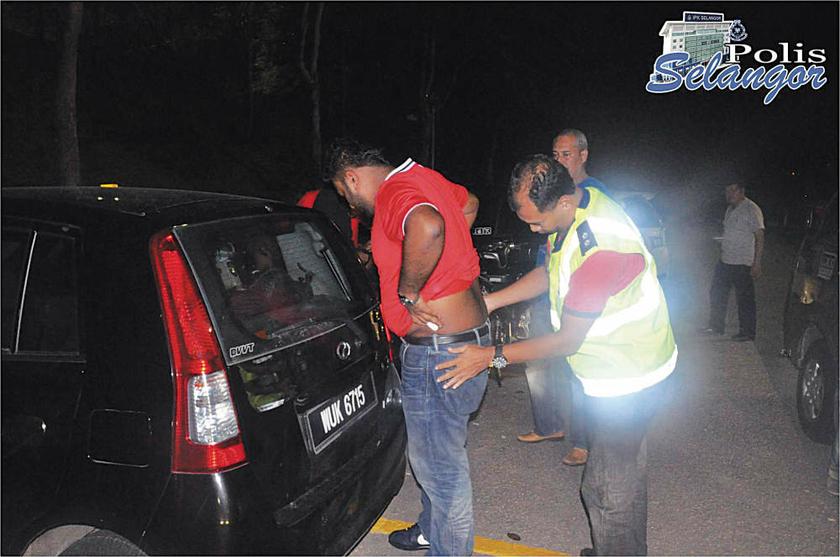 A policeman frisking the driver of a vehicle during a major operation to weed out bad hats in Taman Sri Andalas, Klang on August 18, 2013.