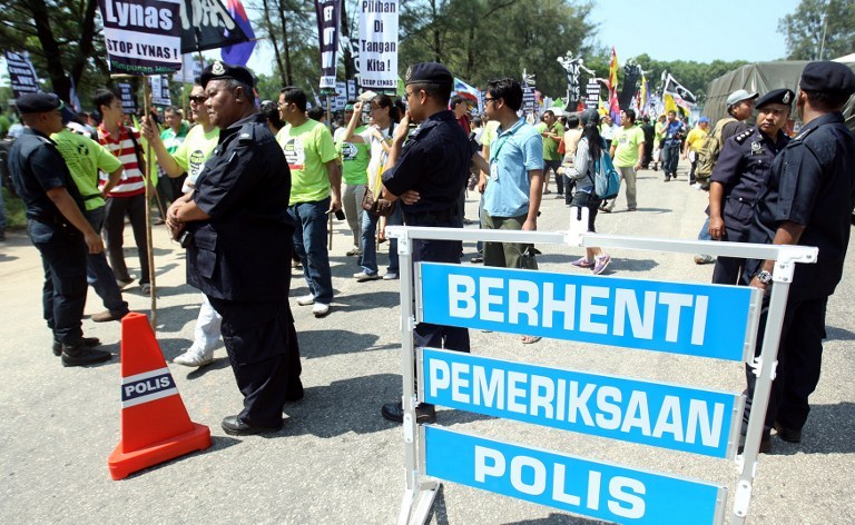 File photo of Malaysian police (in foreground) standing guard during a rally against Australian miner Lynas Corporation in Kuantan on June 24, 2012. Hundreds of activists gathered to protest against the Australian miner, who is building a rare earths plan