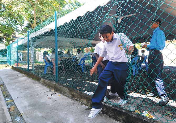 A SJK (T) Seaport student makes a quick exit from the makeshift tent classroom in Kelana Jaya.