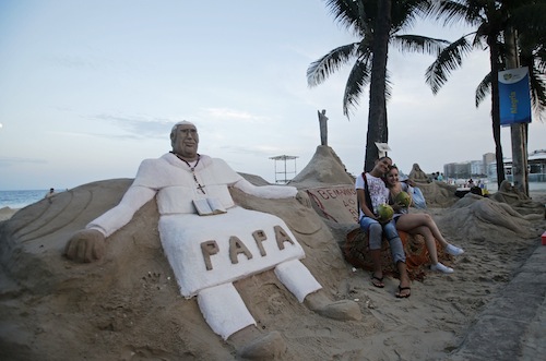 Tourists pose for a photo in front of a Pope Francis sand sculpture at Copacabana beach in Rio de Janeiro July 21, 2013. u00e2u20acu201d Reuters pic