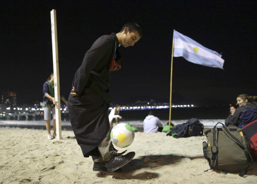 A priest plays with a volleyball ball while Pope Francis at Copacabana Beach celebrates mass on his sixth day in Rio de Janeiro, July 27, 2013. u00e2u20acu201c Reuters pic