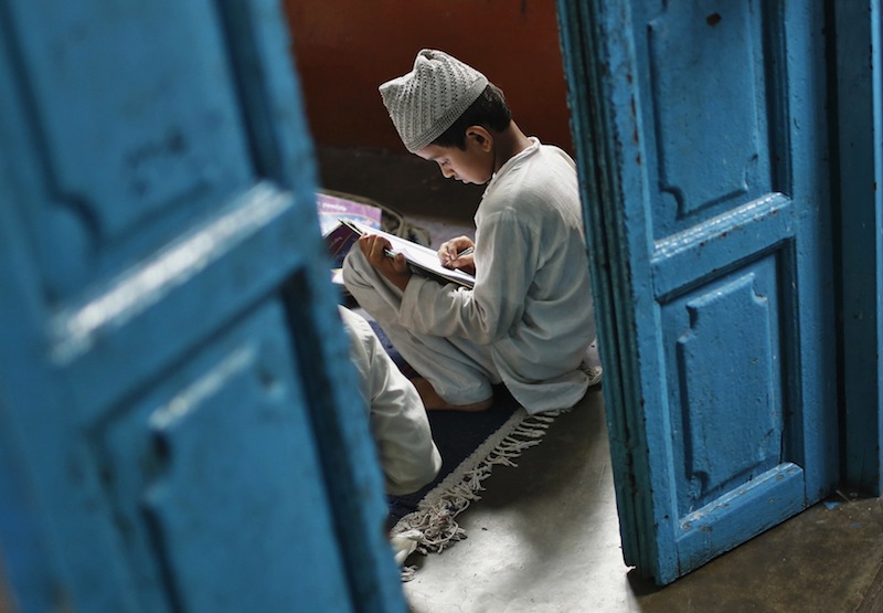 A Muslim boy learns to read the Quran at a madrassa, or religious school, during the holy month of Ramadan in the old quarters of Delhi July 31, 2013. u00e2u20acu201d Reuters pic