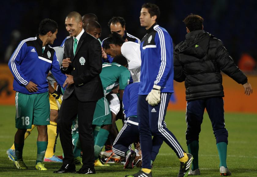 Raja Casablanca players take off the boots of Atletico Mineiro's Ronaldinho (centre in white top) after their FIFA Club World Cup semi-final match at Marrakech stadium December 18, 2013. u00e2u20acu201d Reuters pic