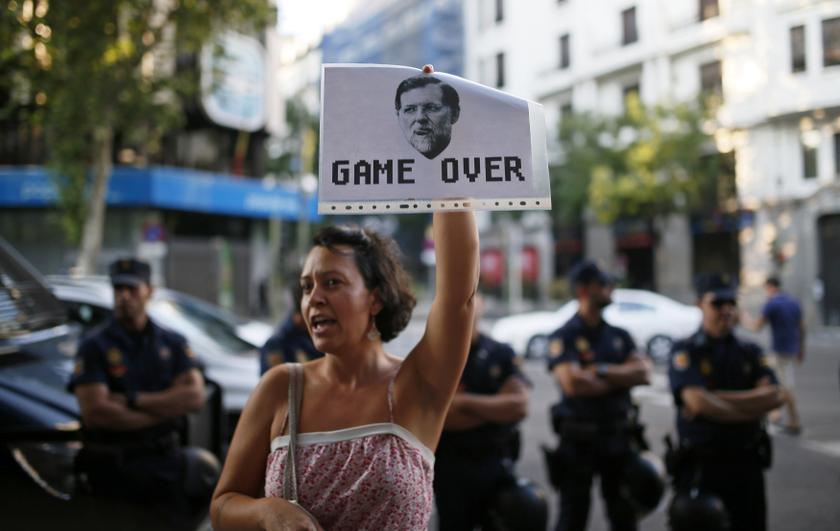 A woman holds a picture of Spain's Prime Minister Mariano Rajoy while protesting outside the People's Party (PP) headquarters in Madrid July 14, 2013. u00e2u20acu201c Reuters pic