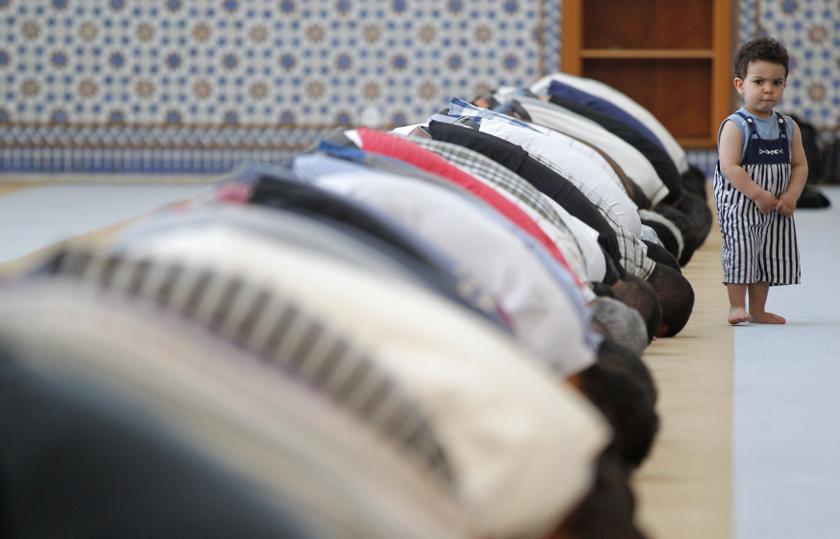 A child walks near members of the Muslim community attending midday prayers at Strasbourg Grand Mosque in Strasbourg on the first day of Ramadan July 9, 2013. u00e2u20acu201c Reuters pic