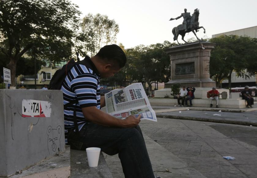 A man reads a newspaper in downtown San Salvador January 31, 2014. u00e2u20acu201d Reuters pic
