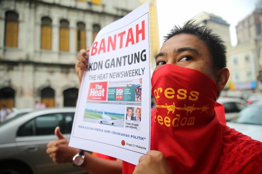A man holds a banner to protest the governmentu00e2u20acu2122s suspension of weekly, The Heat, in Kuala Lumpur January 4, 2014. u00e2u20acu201d Picture by Choo Choy May