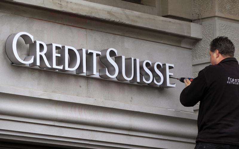 A worker uses a cordless screwdriver to fix the logo of Swiss bank Credit Suisse at a branch office in Zurich February 4, 2013. u00e2u20acu201d Reuters pic