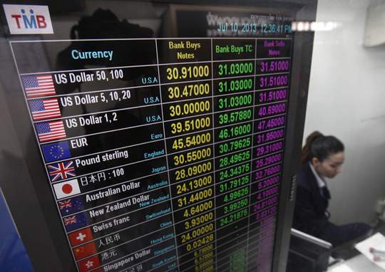 A banker works at a currency exchange in Bangkok July 10, 2013. u00e2u20acu201d Reuters pic