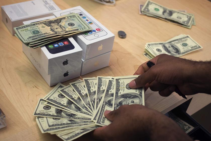 A cashier counts US dollars next to five new Apple iPhone 5S phones at the Apple Retail Store on Fifth Avenue in Manhattan, New York September 20, 2013. u00e2u20acu201d Reuters pic