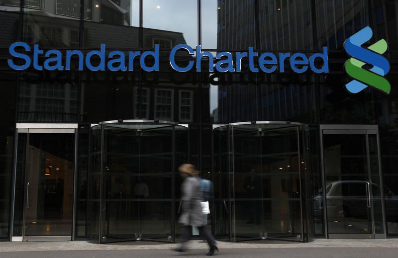 A woman walks past a Standard Chartered bank in London October 13, 2010. u00e2u20acu201d Reuters pic