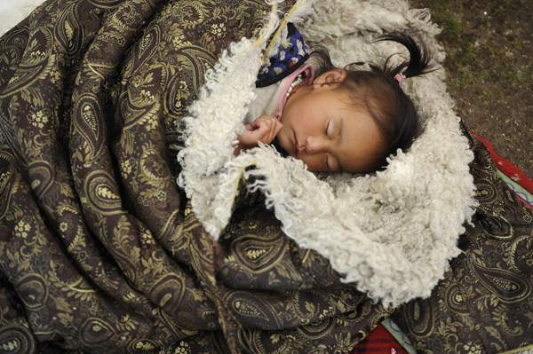 A Tibetan girl sleeps in a blanket in Yangkang township of Tianjun county, Qinghai province July 19, 2013. u00e2u20acu201d Reuters pic