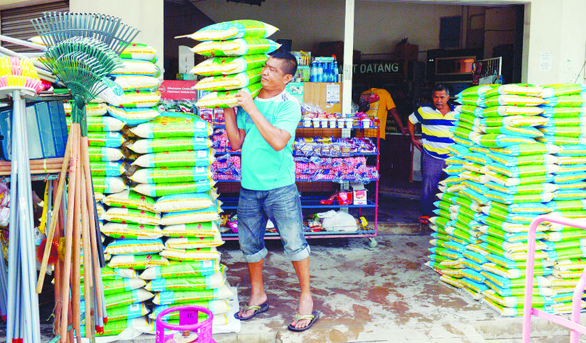 Muhamad Rani Ibrahim delivers rice to a sundry shop in Kemaman after the floodwaters receded. He had been unable to do so for days when the roads were flooded. 
