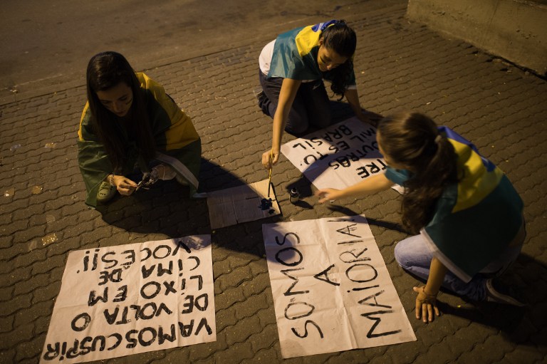 Women compose their banners as thousands of protestors march in downtown Niteroi, near Rio de Janeiro, on June 19, 2013, during a protest against the RM48 billion being spent on this month's Confederations Cup. u00e2u20acu201c AFP pic