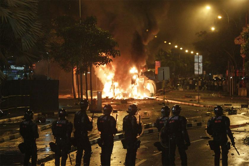 Riot policemen stand guard near a burning vehicle during a riot Singapore's Little India district December 8, 2013. u00e2u20acu201d Reuters pic