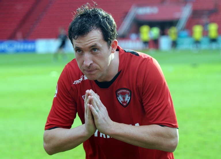 Former Liverpool Football Club and England striker Robbie Fowler gives a Thai traditional greeting to fans in a Muang Thong United jersey after a press conference at the club's headquarters in Bangkok on July 10, 2011. u00e2u20acu201d AFP pic