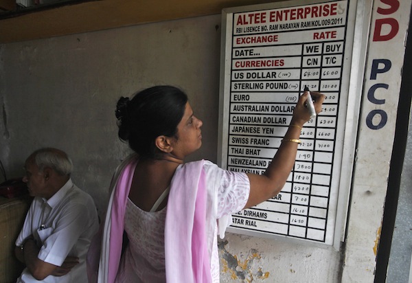 A shopkeeper writes currency exchange rates on a board inside a currency exchange shop in Kolkata August 29, 2013. u00e2u20acu201d Reuters pic