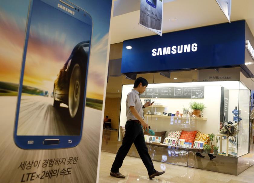 A man using his mobile phone walks past a Samsung Electronics shop in the company's main office building in central Seoul July 23, 2013. Reuters pic