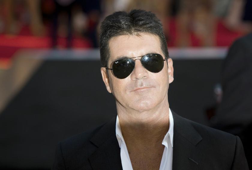 Television mogul Simon Cowell poses for photographers as he arrives for the film ,One Direction: This is Us,, in London August 20, 2013. REUTERS