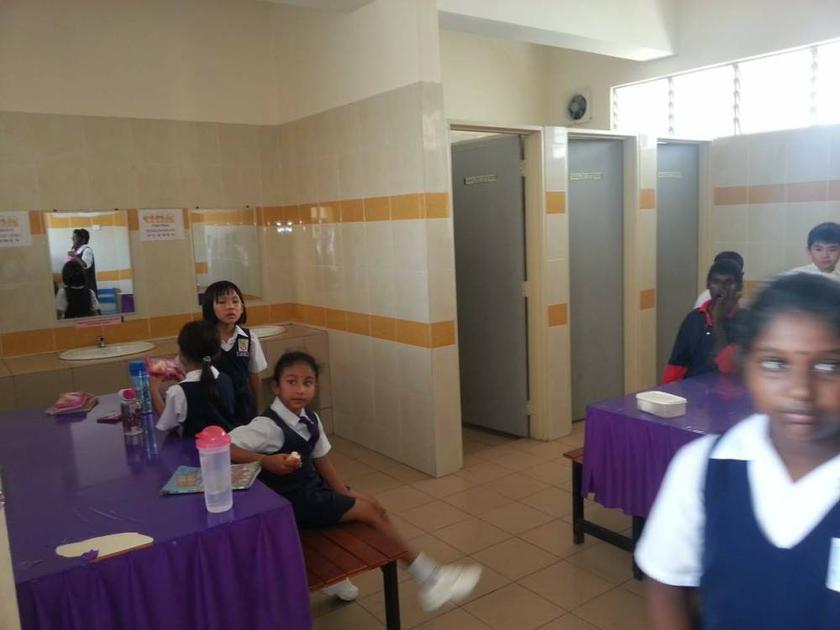 Students are seen eating their recess meals inside the toilet. 