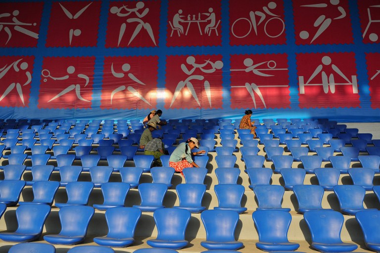 This picture taken on March 6, 2013 shows workers cleaning the seats at the Wunna Theikdi football stadium, a venue for the upcoming Southeast Asian (SEA) Games in Naypyidaw. u00e2u20acu201d AFP pic