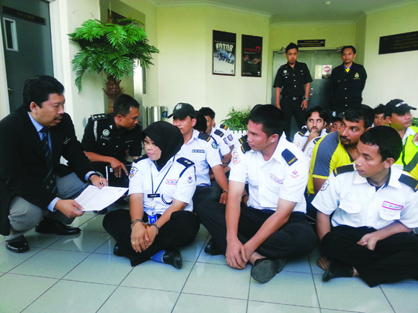 Basri (left) with some of those detained foreigners working as security giards.