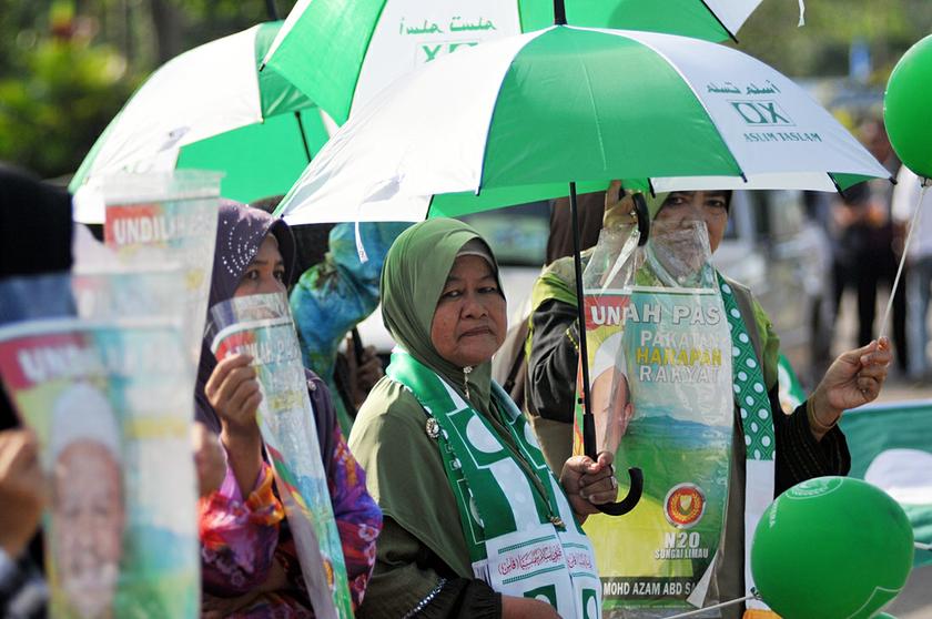 Female supporters of the Sungai Limau PAS candidate, Mohd Azam Abdul Samat, hold posters near the polling station during the polling day, November 4, 2013. u00e2u20acu201d Picture by K.E. Ooi