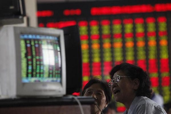 Investors look at computer screens in front of an electronic board showing stock information at a brokerage house in Shanghai, July 1, 2013. u00e2u20acu201d Reuters pic