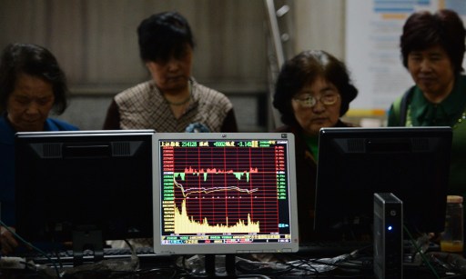 Investors look at stock prices at a securities exchange in Shanghai on June 13, 2013. u00e2u20acu201d AFP pic