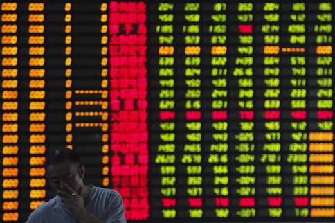 An investor smokes in front of an electronic board showing stock information at a brokerage house in Shanghai June 25, 2013. u00e2u20acu201d Reuters pic